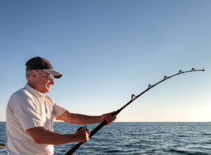 An older gentleman fishing off a boat.