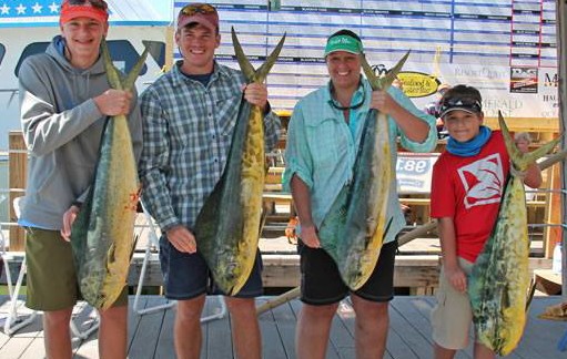 fishermen holding mahi fish