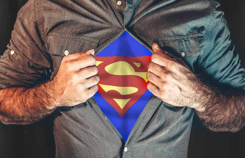 A person ripping open shirt with superman insignia on the inside.